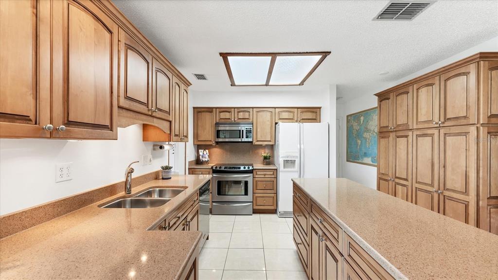 4515 Mangrove Point Road Bradenton, FL 34210 - Photo 16 of 59 a kitchen with stainless steel appliances granite countertop a sink a stove and a refrigerator