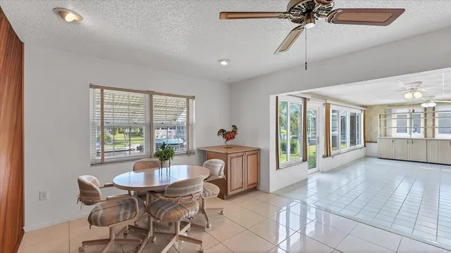 a living room with furniture potted plant kitchen view and a chandelier