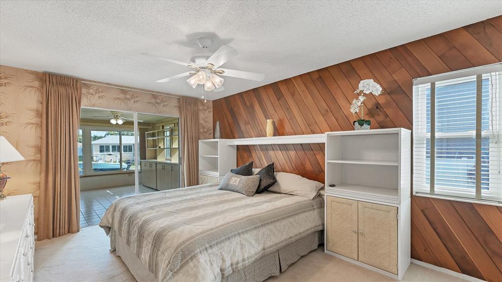 4515 Mangrove Point Road Bradenton, FL 34210 - Photo 21 of 59 a bedroom with a large bed and a chandelier