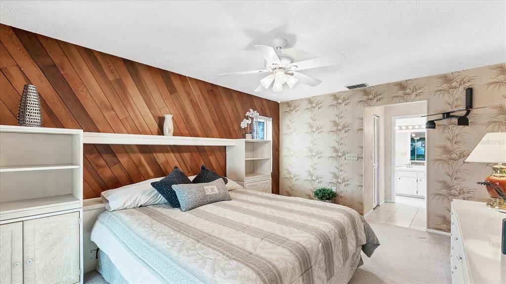 4515 Mangrove Point Road Bradenton, FL 34210 - Photo 23 of 59 a bedroom with a bed and a chandelier