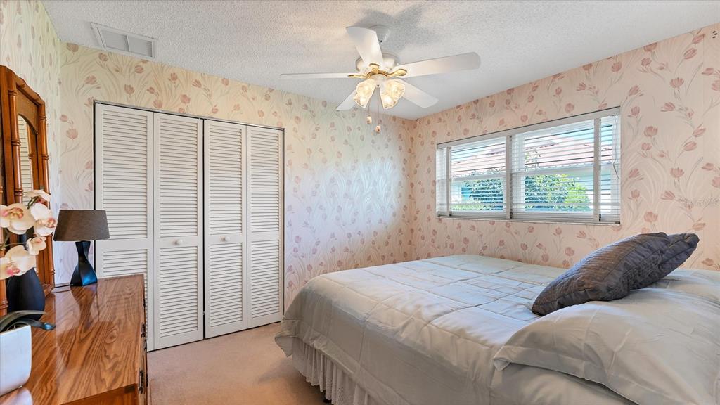 4515 Mangrove Point Road Bradenton, FL 34210 - Photo 25 of 59 a bedroom with a large bed and a chandelier
