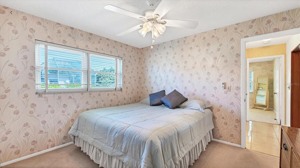 4515 Mangrove Point Road Bradenton, FL 34210 - Photo 26 of 59 a bedroom with a bed and a chandelier