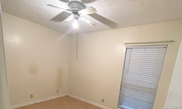 an empty room with a chandelier fan
