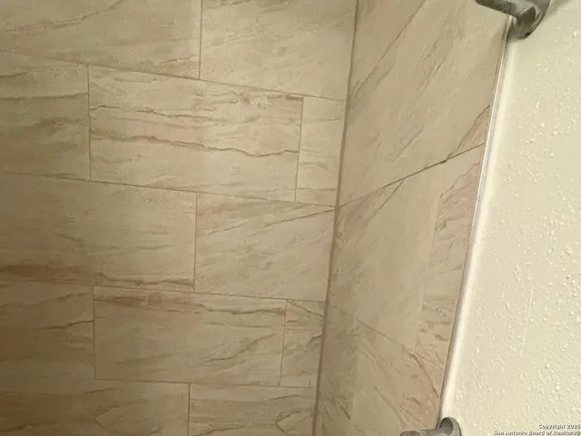 a bathroom with a glass shower door and a sink