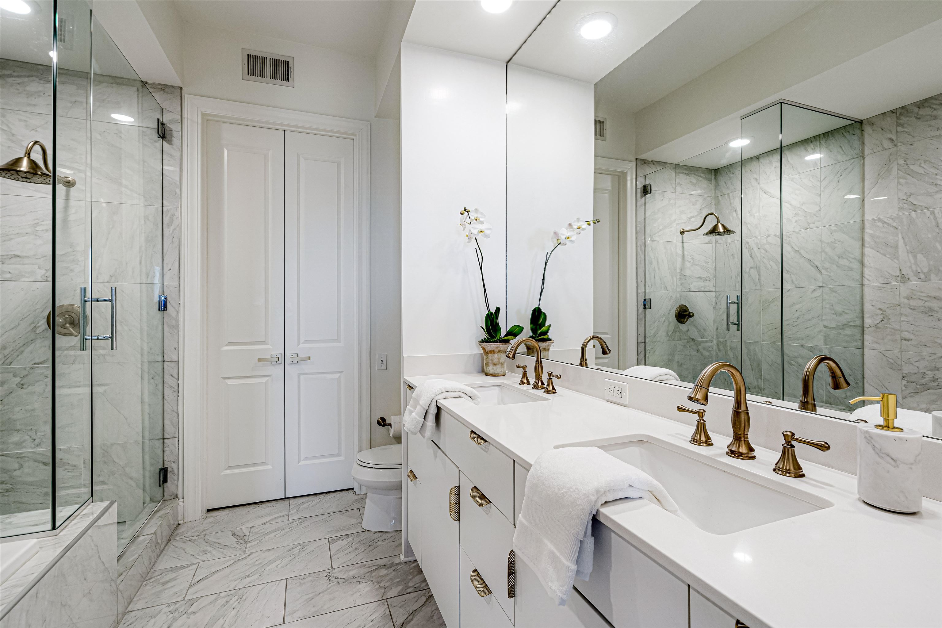 717 Riverside Drive, Unit 1205 Memphis, TN 38103 - Photo 17 of 32 Full bath featuring double vanity, light marble finish flooring, a marble finish shower, a closet, and recessed lighting