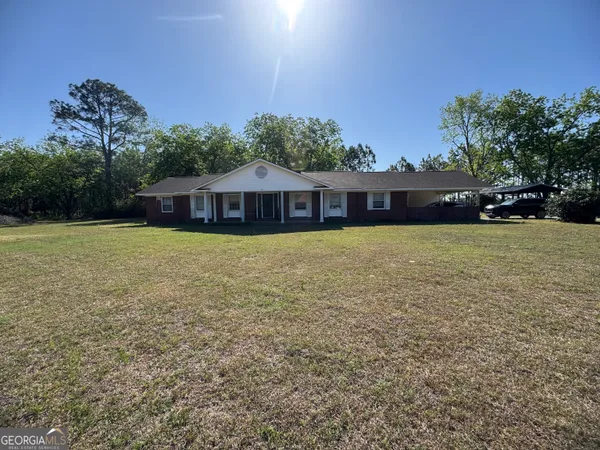 a view of a house with a yard and sitting area