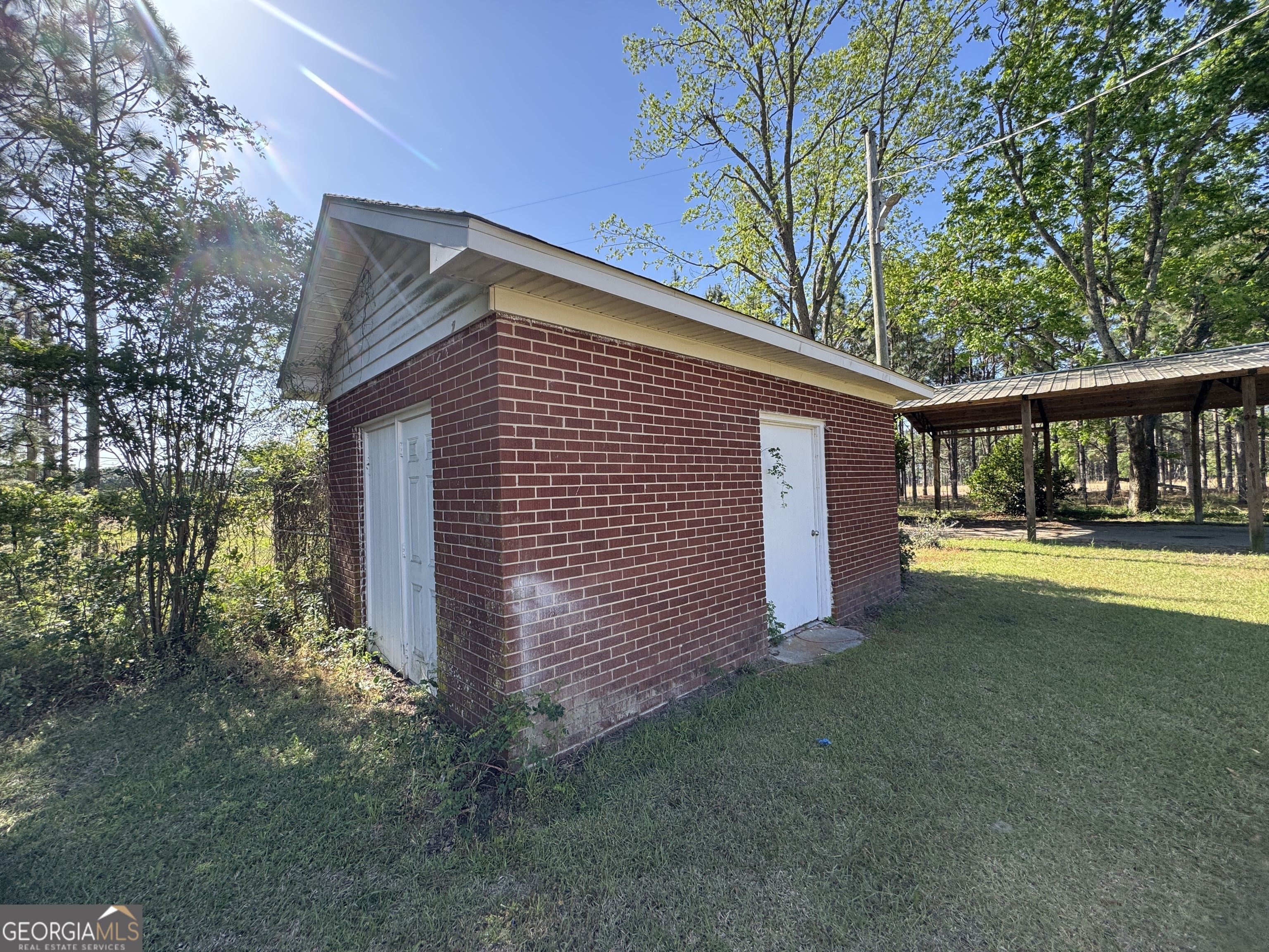 7290 Nevils Groveland Road Pembroke, GA 31321 - Photo 11 of 45 a view of backyard with large trees and wooden fence