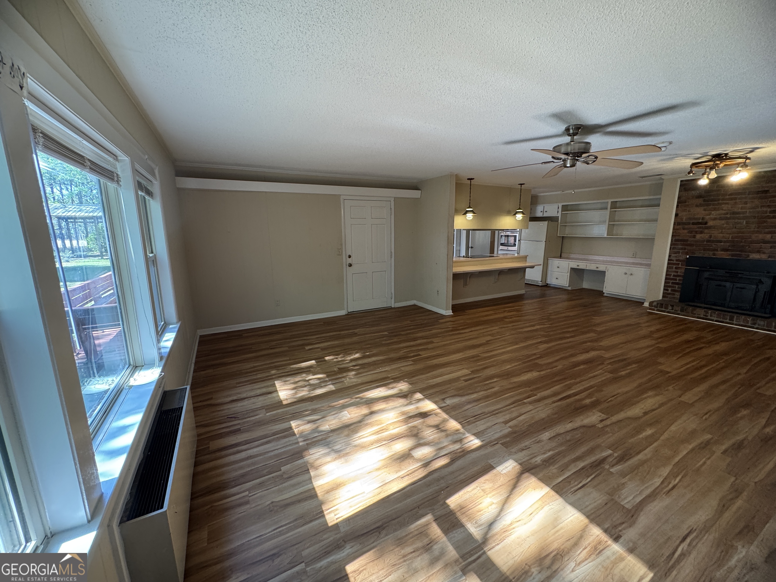 7290 Nevils Groveland Road Pembroke, GA 31321 - Photo 21 of 45 a view of a livingroom with wooden floor and a ceiling fan