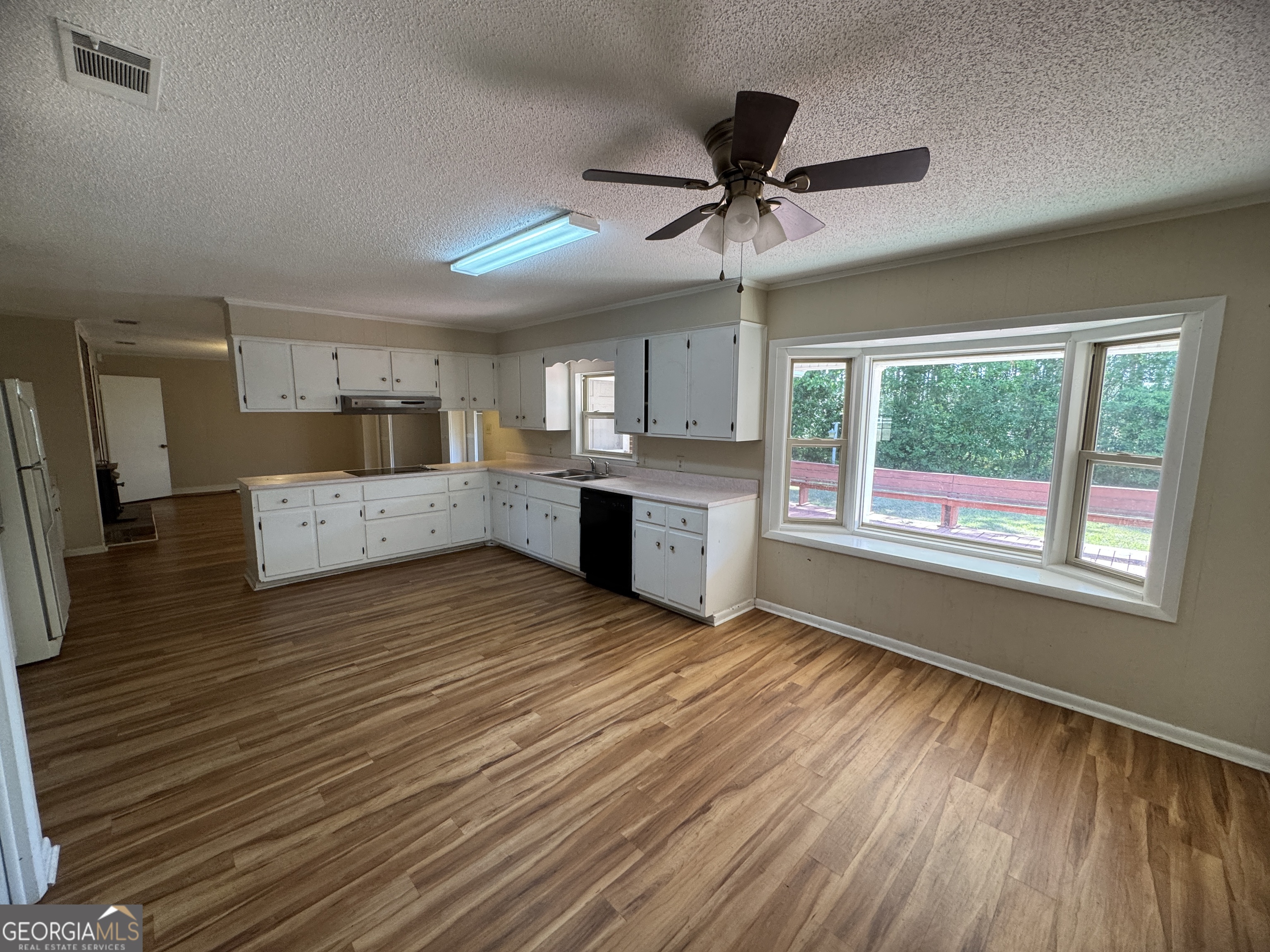 7290 Nevils Groveland Road Pembroke, GA 31321 - Photo 28 of 45 a large kitchen with stainless steel appliances a large window a wooden floor and a window