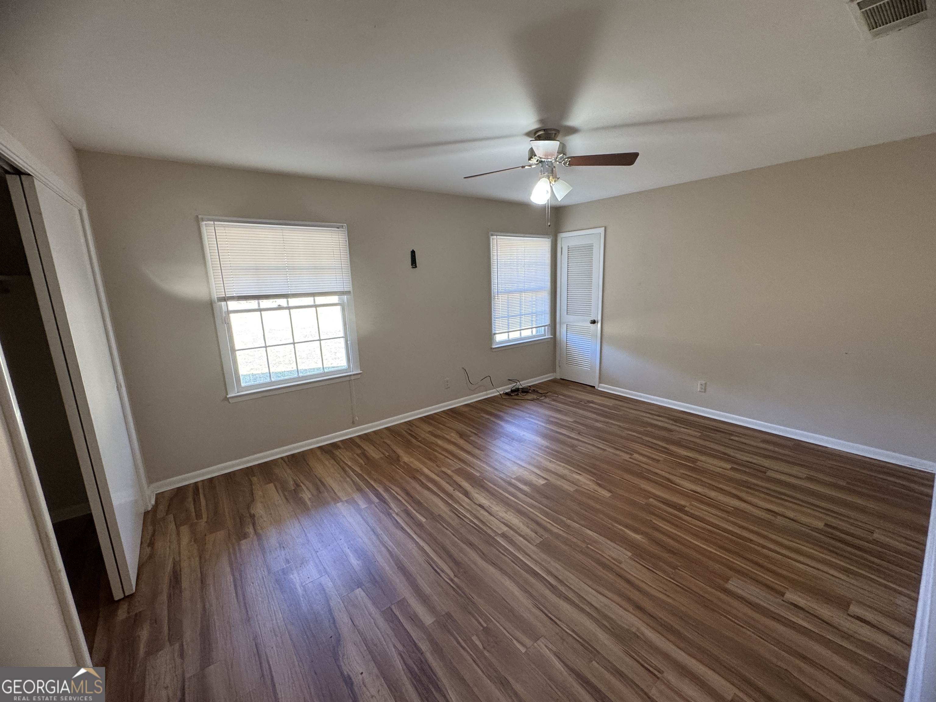 7290 Nevils Groveland Road Pembroke, GA 31321 - Photo 36 of 45 a view of an empty room with wooden floor and a window