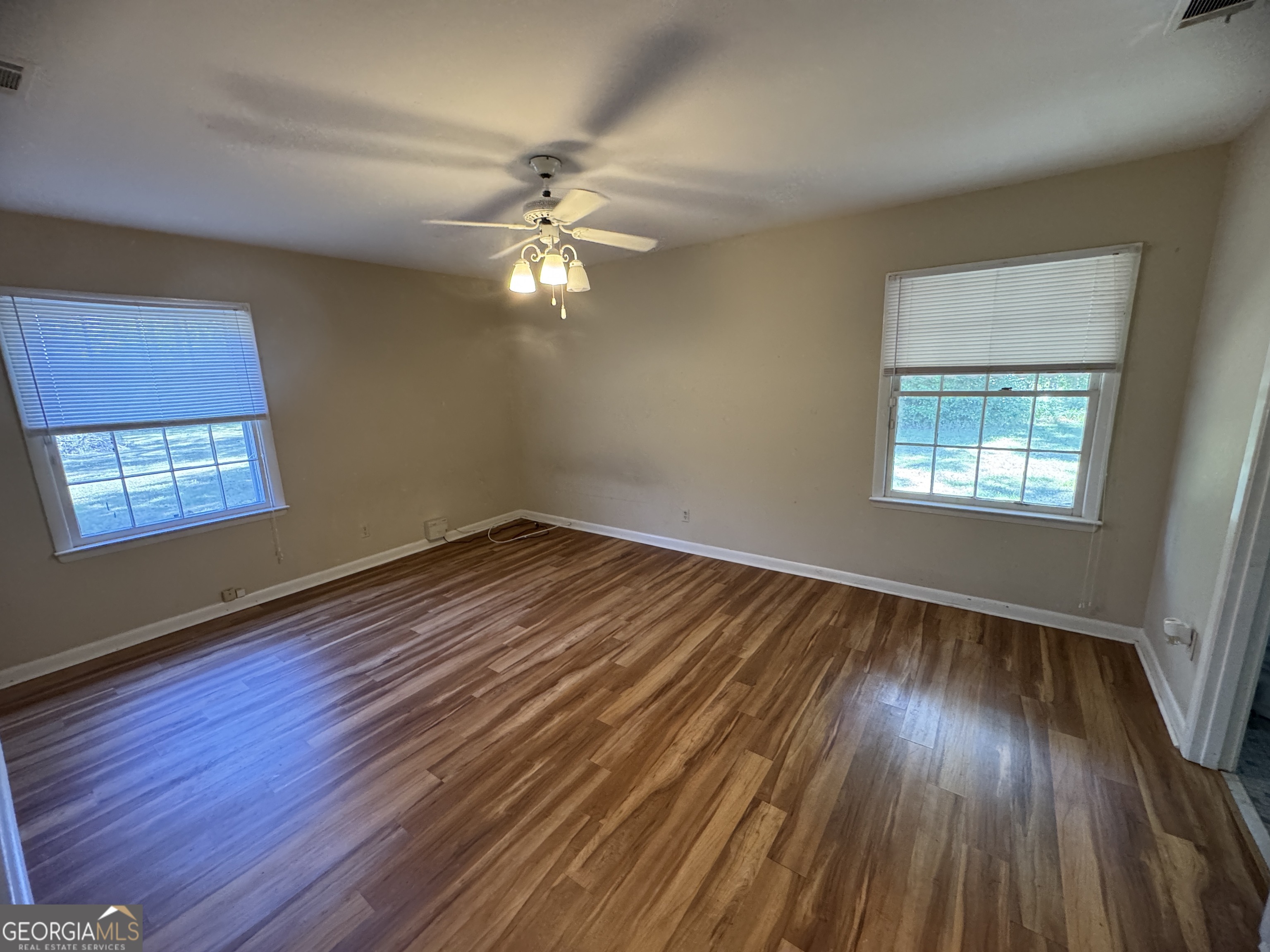 7290 Nevils Groveland Road Pembroke, GA 31321 - Photo 42 of 45 a view of empty room with wooden floor and fan