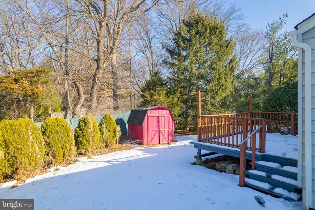 a view of wooden deck with a bench and wooden fence