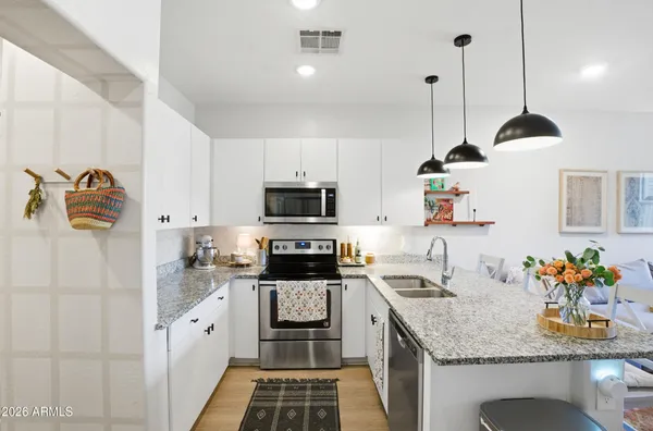 a kitchen with stainless steel appliances granite countertop a sink stove and refrigerator