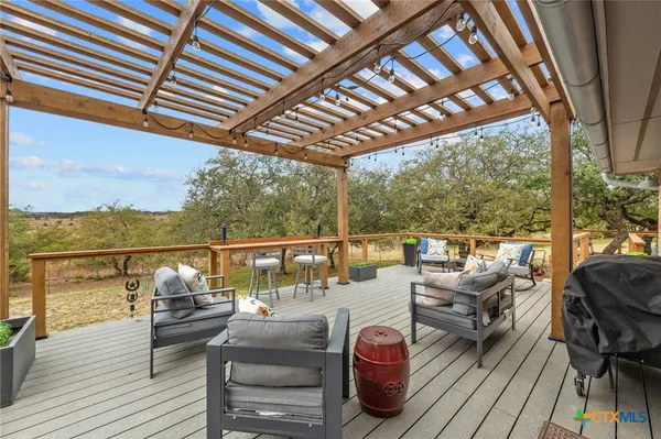 a balcony with wooden floor and outdoor seating