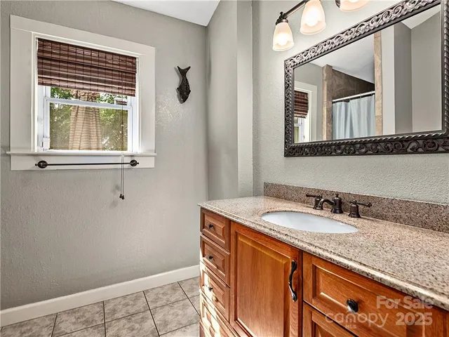 a bathroom with a granite countertop sink and a mirror
