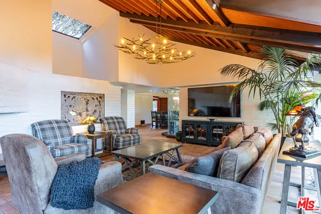 a living room with furniture a chandelier and a flat screen tv