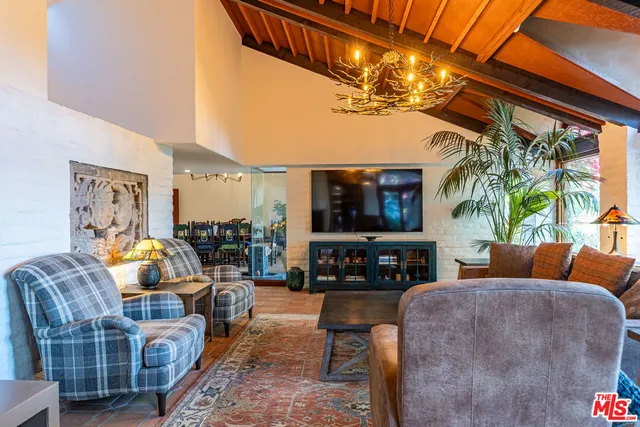 a living room with furniture a flat screen tv and a chandelier