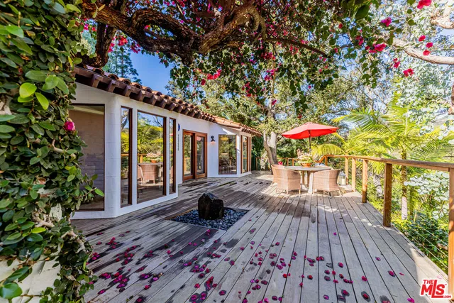 a roof deck with wooden floor and fence
