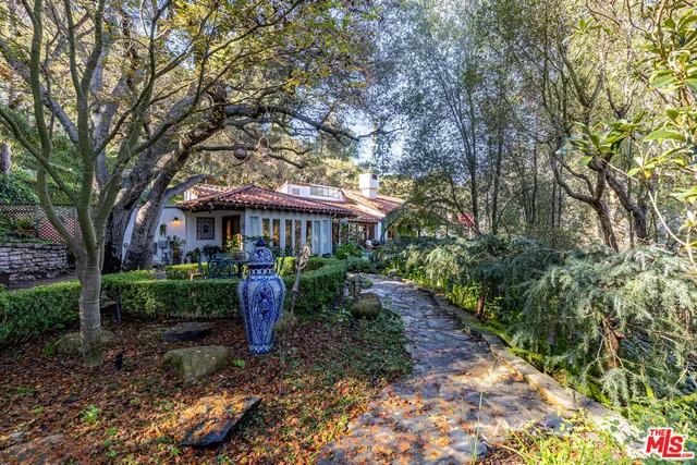a front view of a house with a yard and shrubs