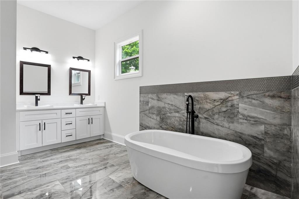 2415 West Rugby Avenue Atlanta, GA 30337 - Photo 16 of 40 a bathroom with a toilet a sink a mirror and bathtub