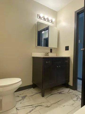 a bathroom with a sink vanity mirror and toilet