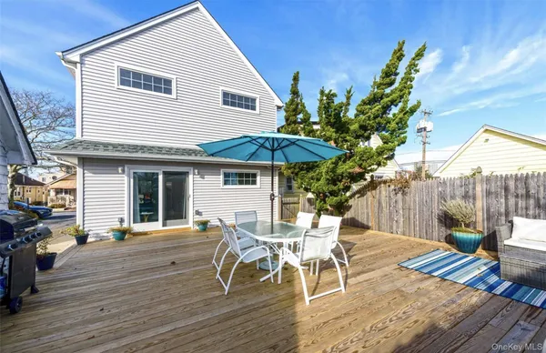 a view of a roof deck with table and chairs under an umbrella with wooden floor