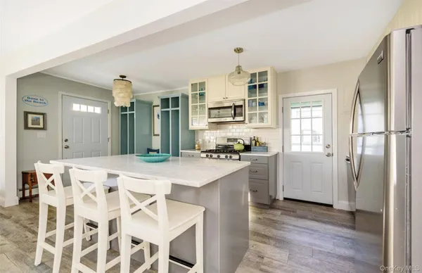 a kitchen with stainless steel appliances kitchen island granite countertop a refrigerator and a sink
