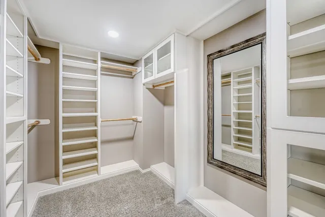 a view of walk in closet with clothes and shoes