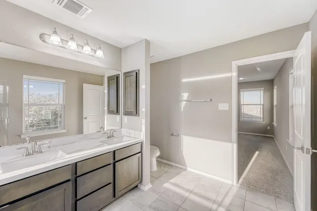 a bathroom with double vanity sink a mirror and a shower
