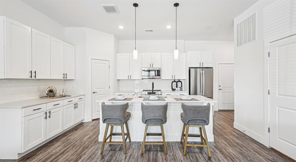 3800 West Lamberth Road, Unit 2703 Sherman, TX 75092 - Photo 4 of 16 a kitchen with stainless steel appliances a white table chairs and a refrigerator