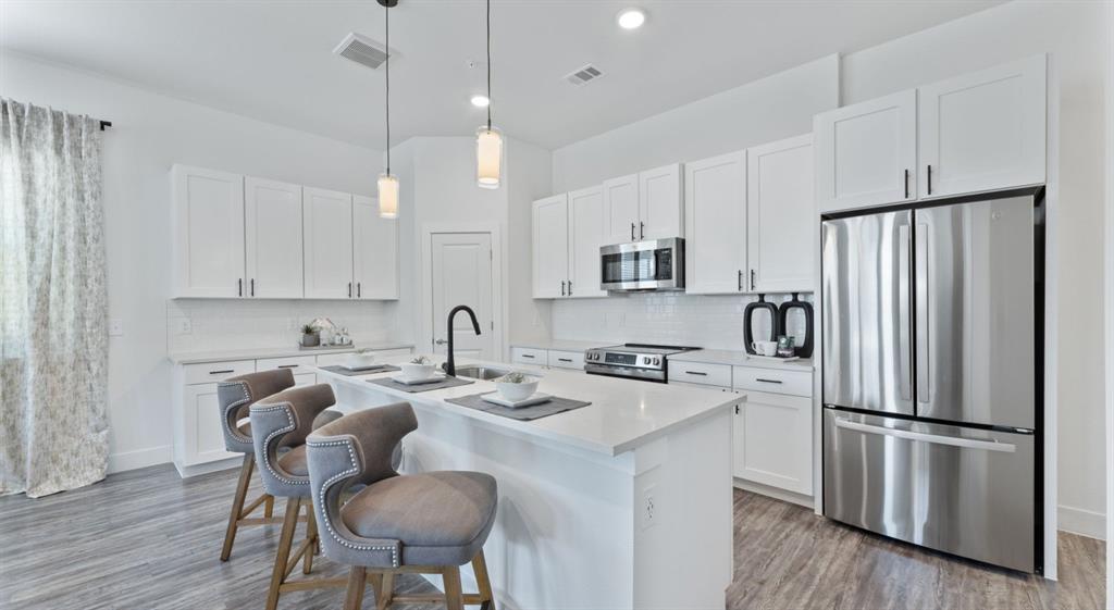 3800 West Lamberth Road, Unit 2703 Sherman, TX 75092 - Photo 7 of 16 a kitchen with stainless steel appliances granite countertop a refrigerator a sink a stove a dining table and chairs