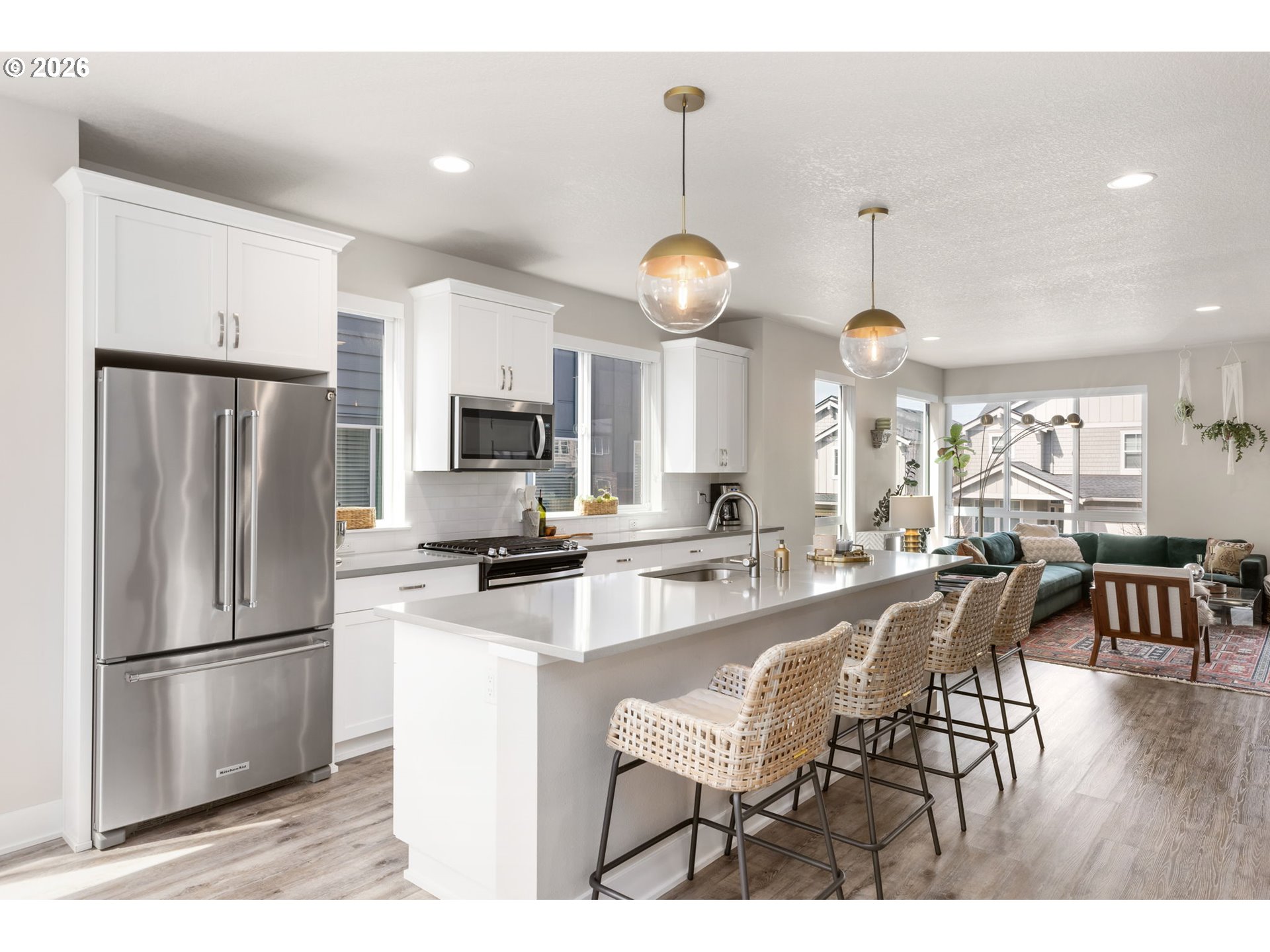 17312 Southwest Kite Lane Beaverton, OR 97007 - Photo 5 of 37 a kitchen with stainless steel appliances a refrigerator a stove a sink a dining table and chairs with wooden floor