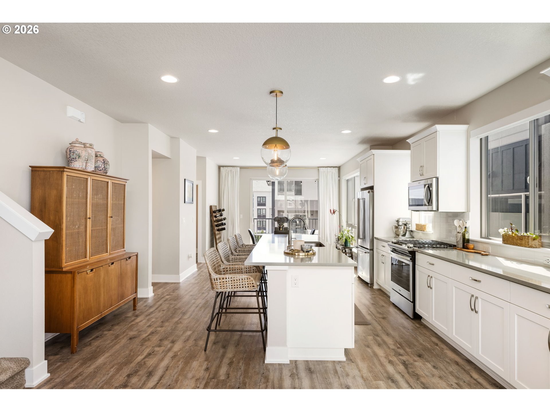 17312 Southwest Kite Lane Beaverton, OR 97007 - Photo 10 of 37 a open kitchen with stainless steel appliances granite countertop a refrigerator a stove a sink dishwasher and white cabinets with wooden floor