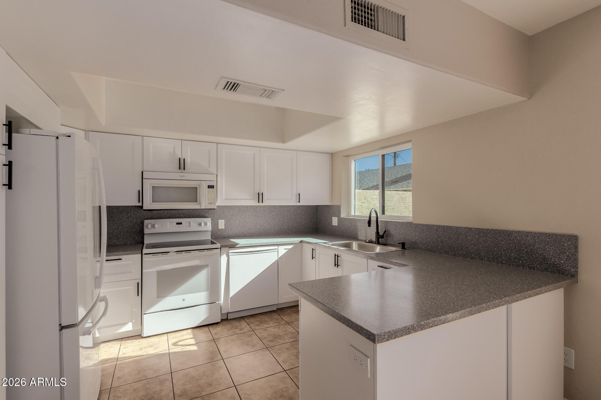6223 North 12th Street, Unit 2 Phoenix, AZ 85014 - Photo 9 of 38 a kitchen with stainless steel appliances granite countertop a sink stove and refrigerator