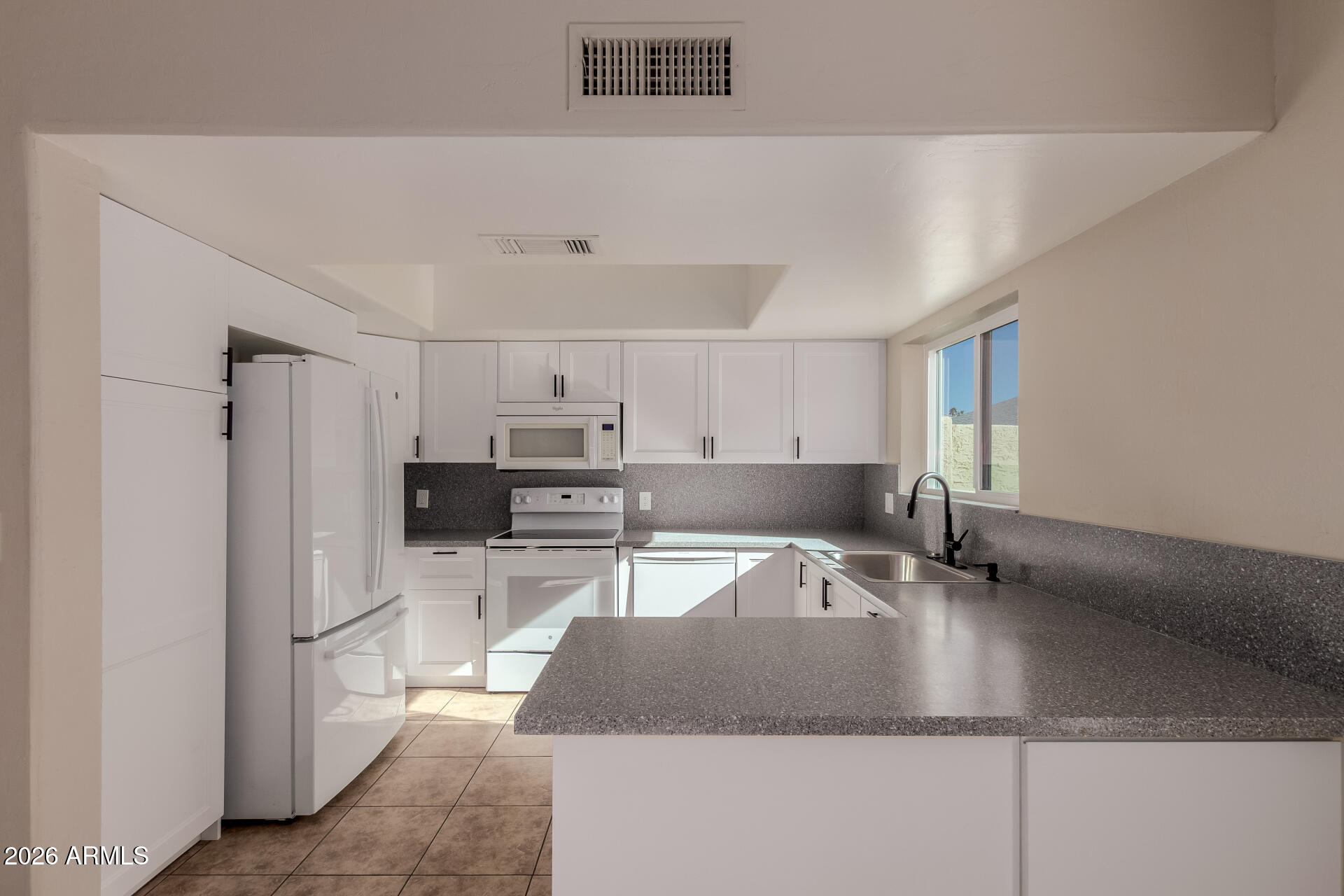6223 North 12th Street, Unit 2 Phoenix, AZ 85014 - Photo 10 of 38 a kitchen with kitchen island a sink a stove and a refrigerator