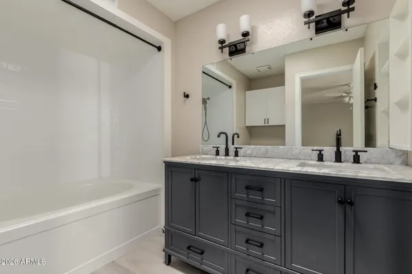 a view of an empty room with chandelier fan and fire place