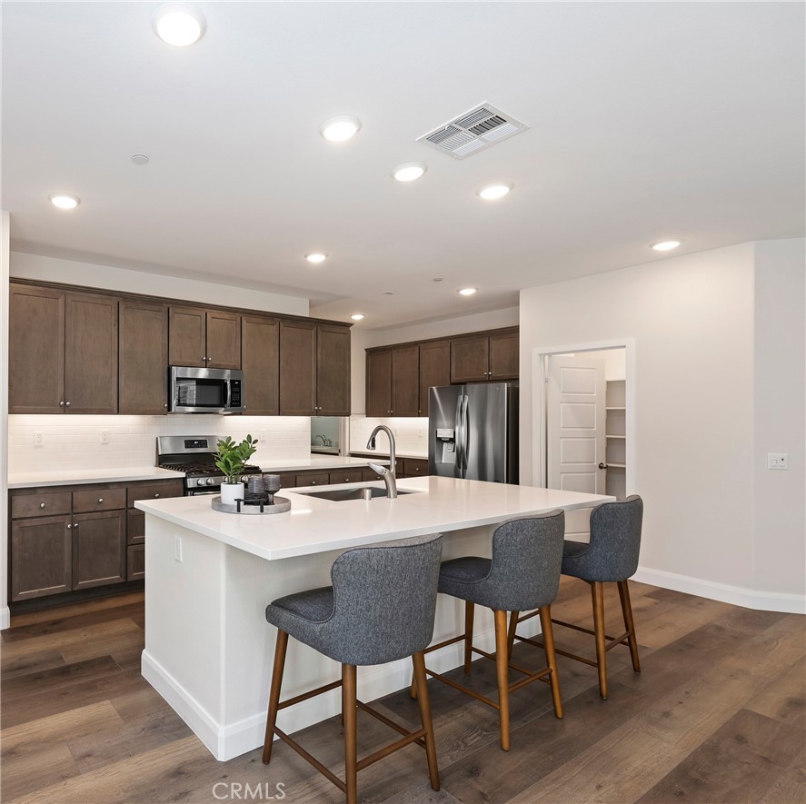 34709 Candlestick Circle Murrieta, CA 92563 - Photo 11 of 40 a kitchen with a table chairs stove and cabinets