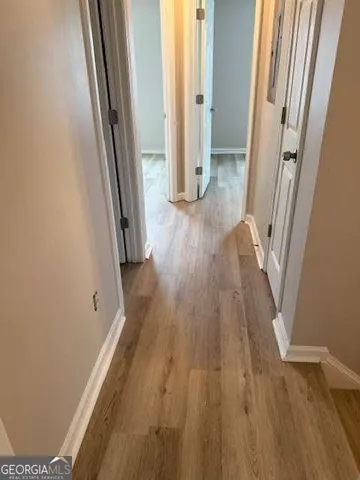 a view of a hallway with wooden floor and staircase