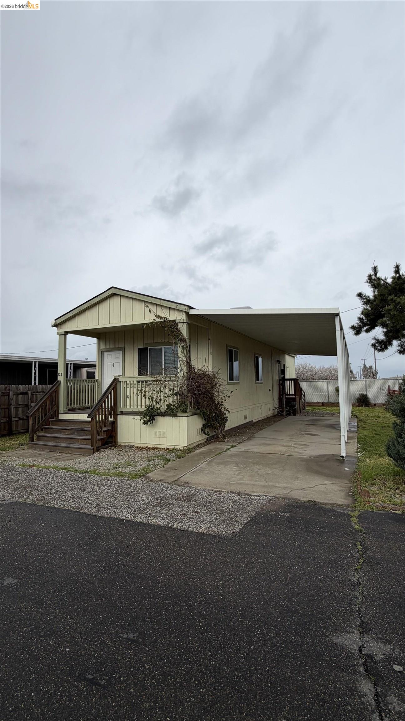 4449 South Carpenter Road, Unit C1 Modesto, CA 95358 - Photo 1 of 1 Manufactured / mobile home with an attached carport, concrete driveway, and board and batten siding