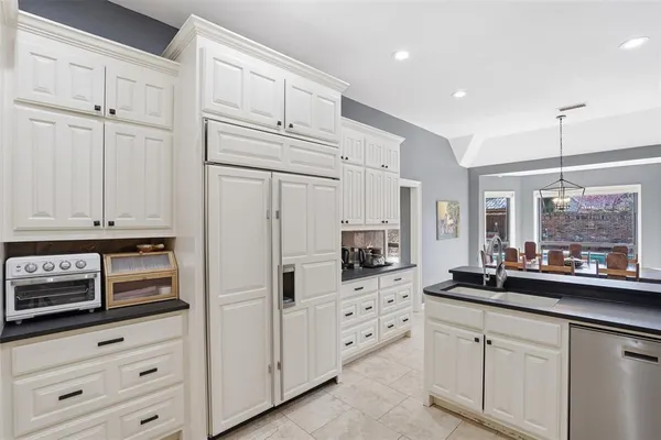 a kitchen with stainless steel appliances white cabinets and a refrigerator