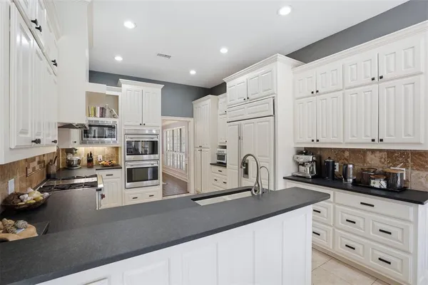 a kitchen with stainless steel appliances and white cabinets