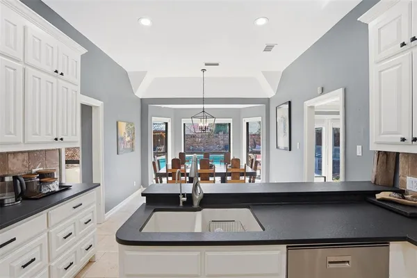 a kitchen with large window a sink and cabinets