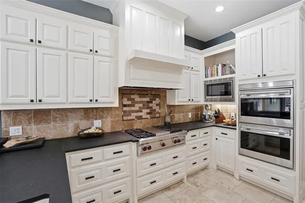 a kitchen with granite countertop white cabinets stainless steel appliances and sink