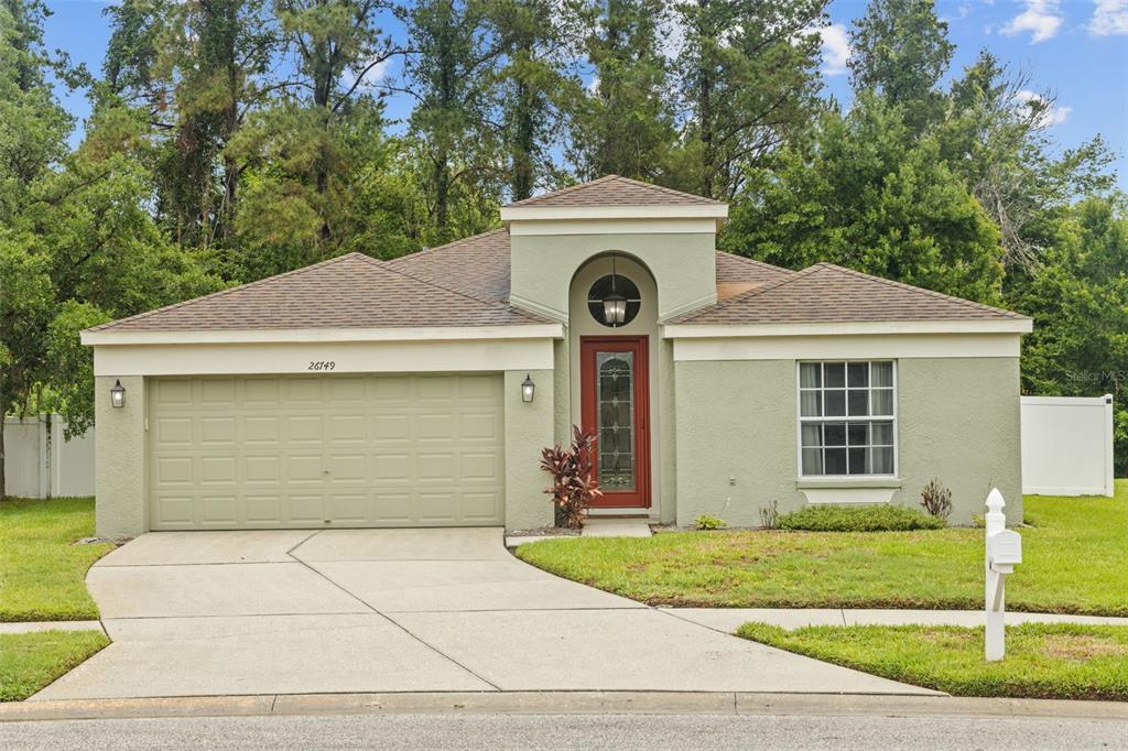 a front view of a house with a garden and garage