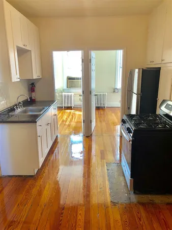 a kitchen with stainless steel appliances granite countertop a stove a sink dishwasher and a flat screen tv