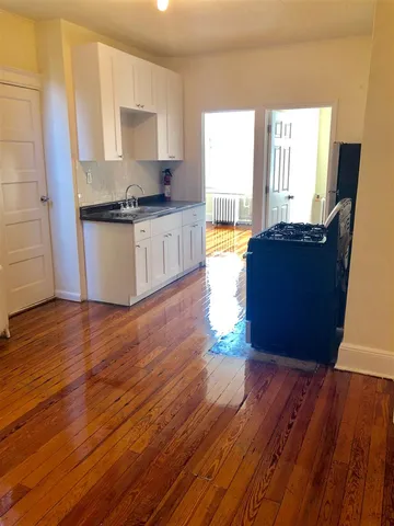 a view of a kitchen with wooden floor and a window