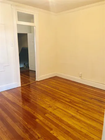 an empty room with wooden floor and a window