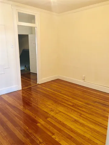 an empty room with wooden floor and a window