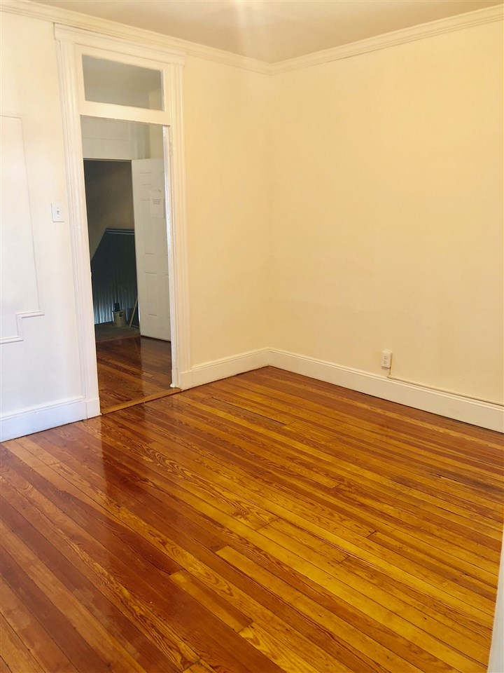 617 Monroe Street, Unit 2 Hoboken, NJ 07030 - Photo 8 of 12 an empty room with wooden floor and a window