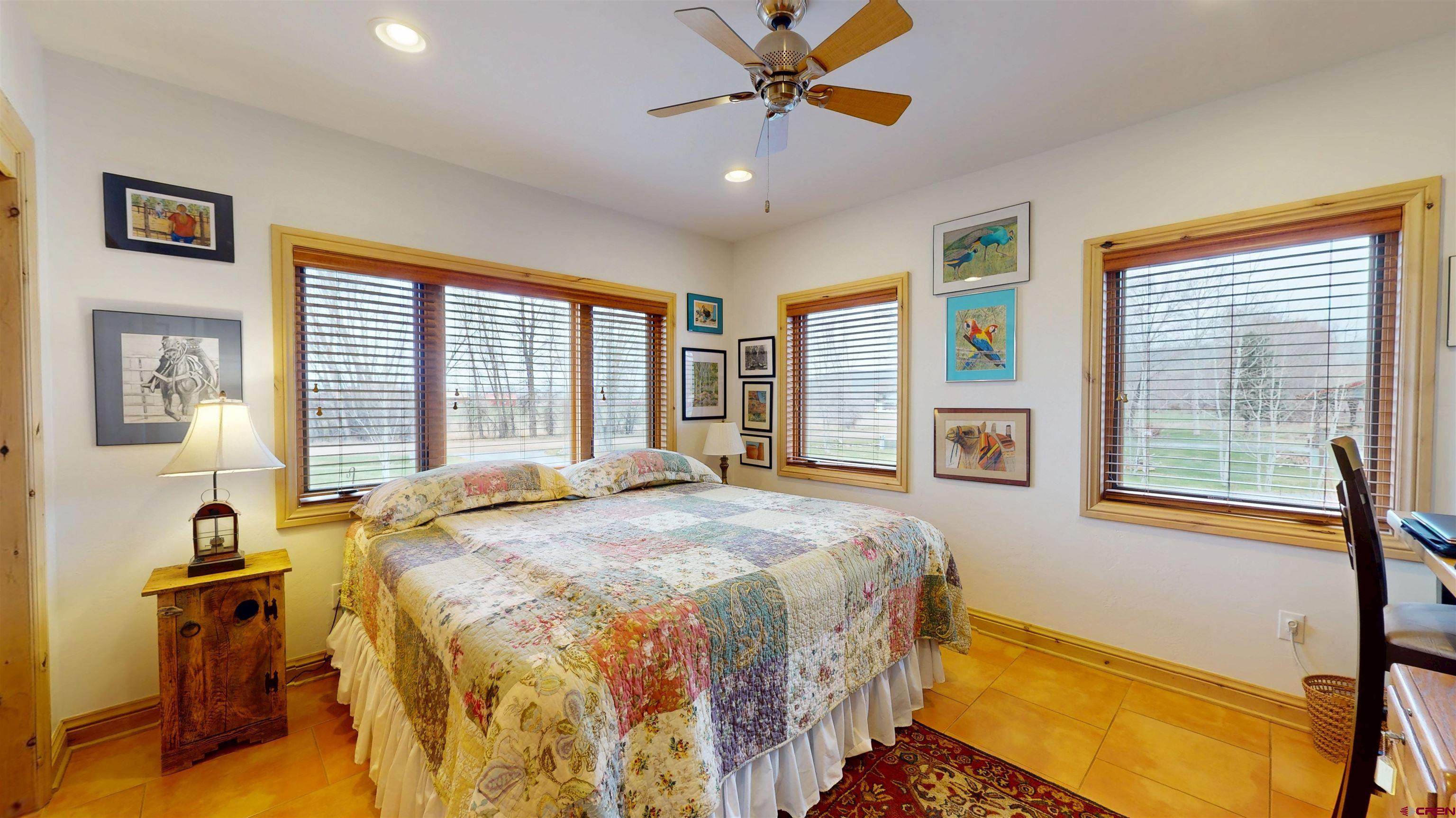 157 Spring Meadow Trail Gunnison, CO 81230 - Photo 31 of 43 a spacious bedroom with a bed and a chandelier